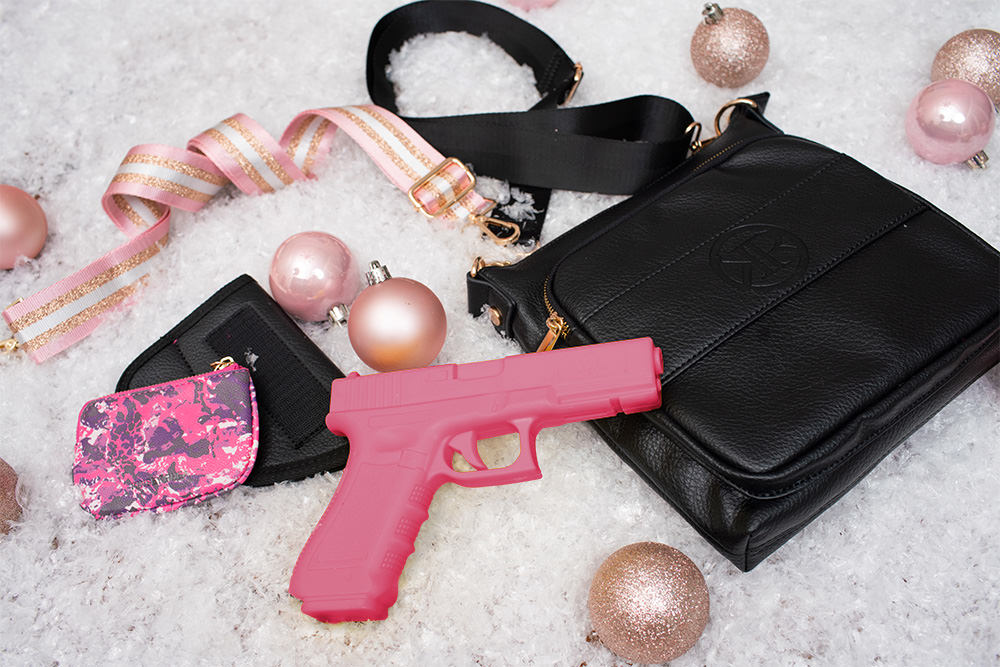 two black concealed carry purse with pink pistol in the middle